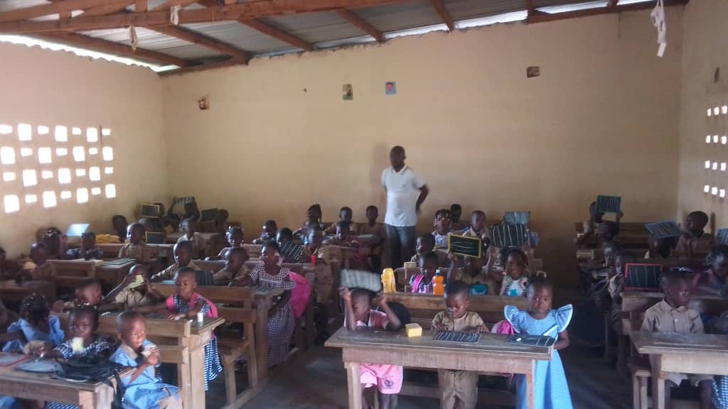 Young students at their desks inside a classroom built by GAD